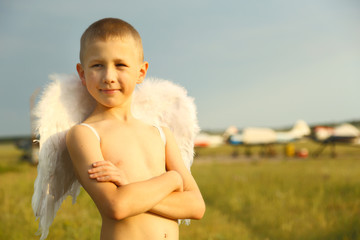 boy with angel wings on the airfield