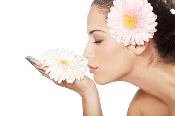Obraz na płótnie Canvas young beautiful woman enjoying the scent of the flower gerbera