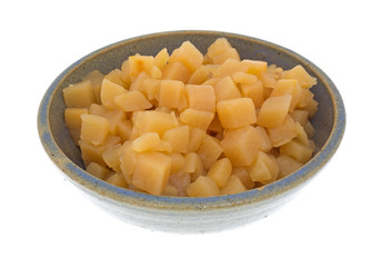 Cubed rutabagas in an old bowl on a white background