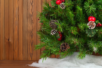 Fragment of Green Decorated Christmas Tree on Wooden Background.