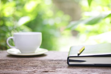 Notebook  and coffee on wooden table