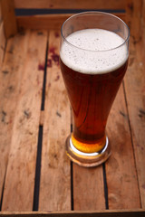 Tall glass of beer in a crate