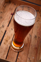 Tall glass of beer in a crate