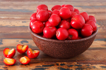 Malpighia glabra (red acerola), tropical fruit  on wooden table