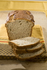 Fresh loaf of white home made bread on table cloth.