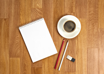 Obraz na płótnie Canvas Blank notepad with office supplies and cup of coffee on wooden t