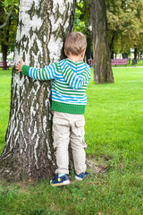 Little boy playing hide and seek in park