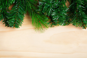 Green fir-tree branches on wooden background