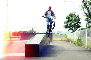 Young boy jumping with his BMX Bike at skate park