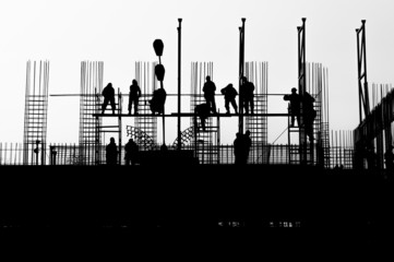 Workers on a building in construction, in backlight