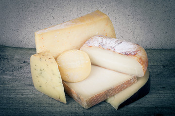 Head and various pieces of cheese on a wooden table.tinted