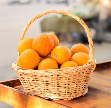 Orange in basket on wooden table