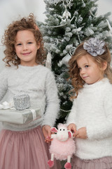 Two child girls with gifts, Christmas tree