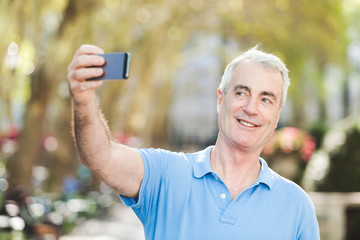 Fototapeta premium Senior Man Taking a Selfie at Park
