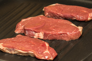 steaks grilling in a pan