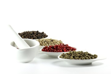Pfefferkörner in Keramikschälchen isoliert auf weißem Hintergrund