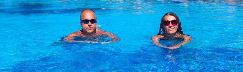 Fototapeta na wymiar Couple swimming in pool