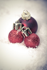 Red christmas baubles on the snow. christmas decorations