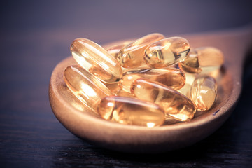 Fish oil capsules in a spoon 