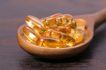 Fish oil capsules in a spoon 