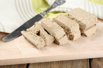 Sunflower halva on cutting board, on wooden background