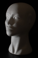 Mannequin head isolated on a black background with side lighting