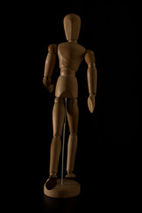 wooden mannequin running on a black background