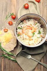 Tasty rice in pan on wooden table