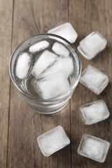 Summer cocktail with ice cubes on wooden table