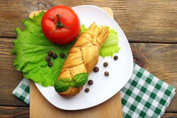 Smoked braided cheese on wooden table