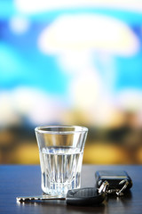 Glass of alcoholic drink and car key,