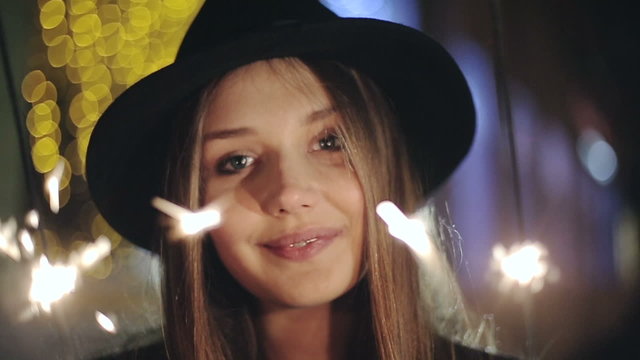 Portrait of a girl model looks with sparklers in their hands