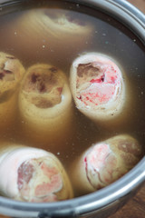 Three pieces of cured pork knuckles in a pot.