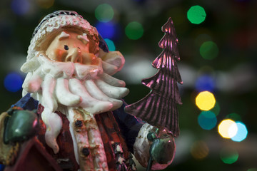 Statuina di Babbo Natale con sfondo di luci colorate
