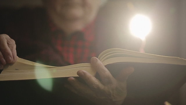 SLOW MOTION: Old human reading a book. Close up