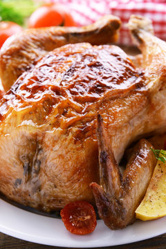 Delicious baked chicken on plate on table close-up © Africa Studio
