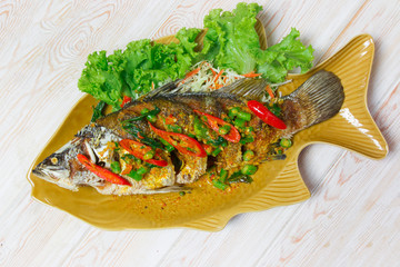 fried fish with fresh herbs and sweet spicy sauce on plate over - 74218394