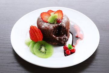 Hot chocolate pudding with fondant centre with fruits, close-up
