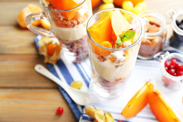 Healthy layered dessert with muesli and fruits on table