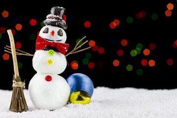 Snowman on bokeh lights background