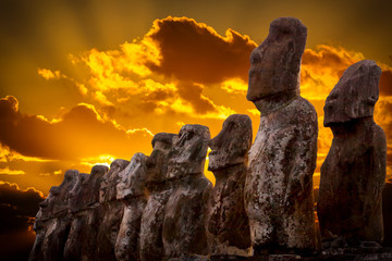 Standing moais with orange clouds in background in Easter Island