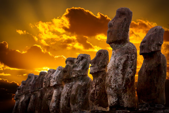 Standing moais with orange clouds in background in Easter Island