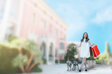 Young girl  with two greyhounds holding  shopping bags