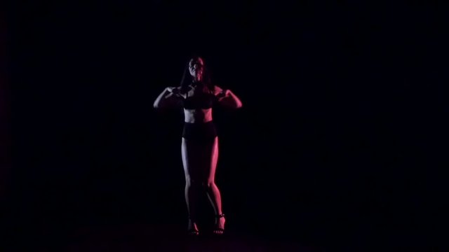 Sexy woman dancing, dark background. Slow motion.