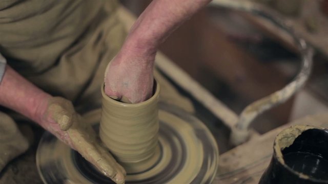 Master making a pot from clay