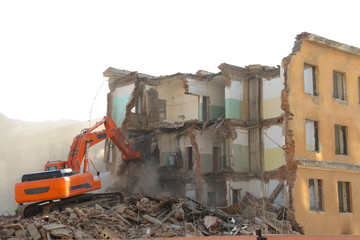 Excavator destroys old house.