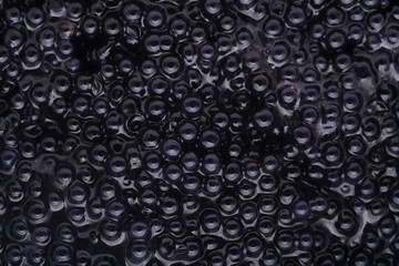 Black caviar background, top view
