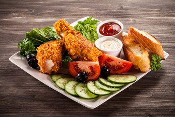 Fried chicken drumsticks and vegetables