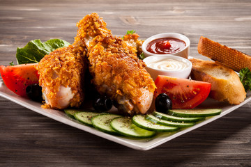 Fried chicken drumsticks and vegetables
