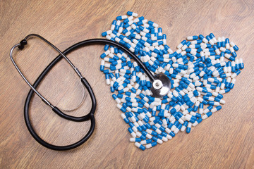 stethoscope and heart made of blue tablets, pills or capsules
